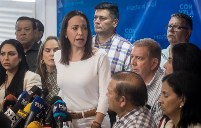 A líder da oposição María Corina Machado (c) dá declarações a jornalistas na companhia do candidato Edmundo Gonzales, na segunda-feira, em Caracas (Venezuela). Machado denunciou na segunda-feira a prisão de Javier Cisneros e Gabriel González, dois colaboradores da campanha presidencial do ex-embaixador Edmundo González Urrutia, elevando para cinco o número total de jovens partidários anti-Chávez presos desde sexta-feira (EFE/ Miguel Gutierrez)