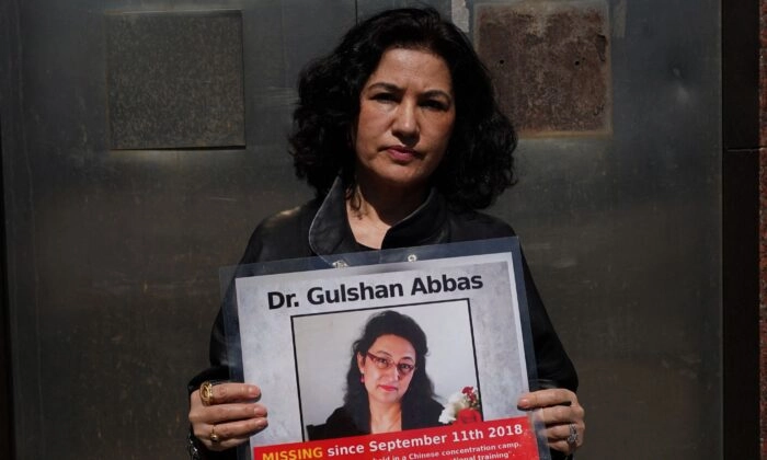 Rushan Abbas, diretora executiva da Campanha para Uigures, segura uma foto de sua irmã, Gulshan Abbas, atualmente presa em um campo chinês, durante um comício em Nova Iorque em 22 de março de 2021 (Timothy Clary/AFP via Getty Images)
