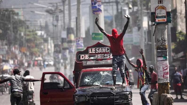 Um homem com o rosto coberto pede que os manifestantes parem durante um protesto contra o governo do primeiro-ministro Ariel Henry em Porto Príncipe, Haiti, em 1º de março de 2024. (Ralph Tedy Erol/Reuters)