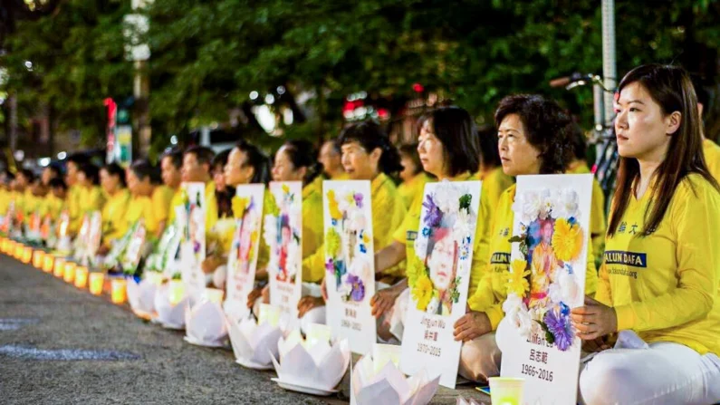 Praticantes do Falun Gong participam de uma vigília à luz de velas, segurando fotos de outros adeptos que morreram como resultado da perseguição na China, em frente ao Consulado Chinês em Toronto, em 13 de julho de 2019 (Epoch Times)
