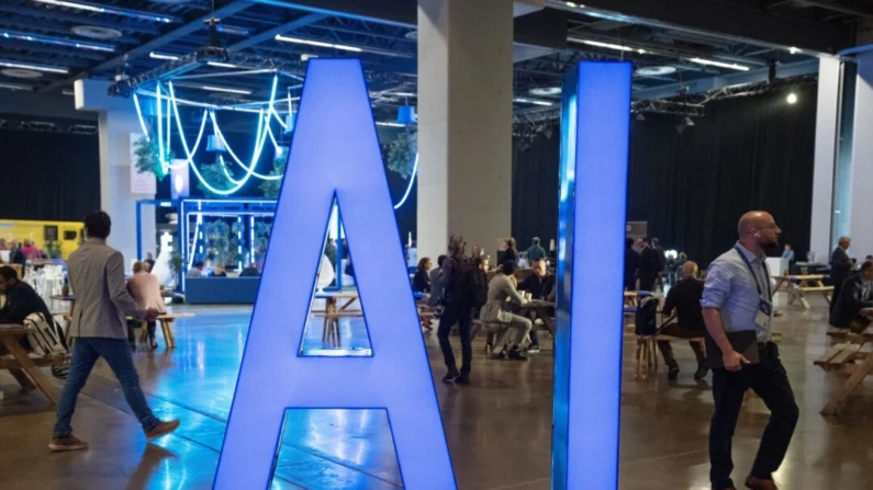 Pessoas passam por uma placa de IA na conferência de inteligência artificial All In em Montreal, em 28 de setembro de 2023 (The Canadian Press/Ryan Remiorz)
