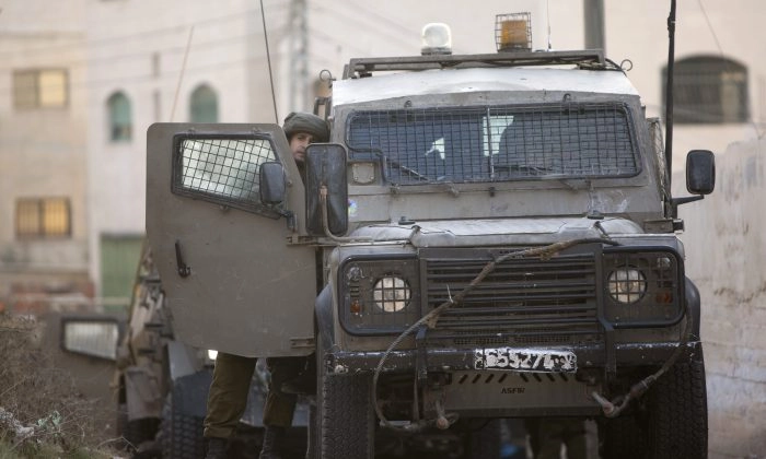 Um soldado israelense fica ao lado de um veículo durante um ataque militar israelense na cidade de Jenin, na Cisjordânia, em 4 de outubro de 2015. (AP Photo/Majdi Mohammed)
