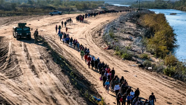 Um grupo de mais de 1.000 imigrantes ilegais caminha em direção a um centro de processamento de campo da Patrulha de Fronteira dos EUA depois de cruzar o Rio Grande vindo do México em Eagle Pass, Texas, em 18 de dezembro de 2023. (John Moore/Getty Images)
