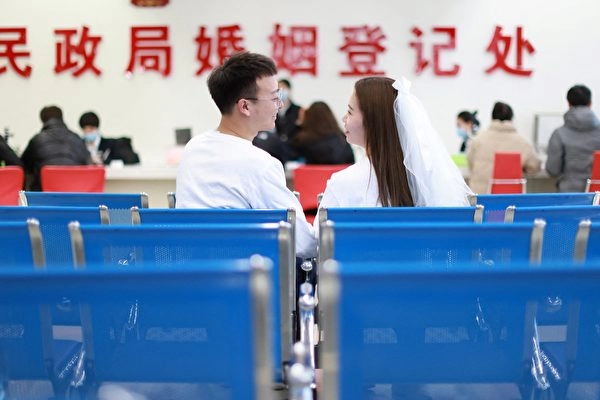 Um jovem casal espera para obter suas certidões de casamento em um cartório de casamento em Shenyang, na província de Liaoning, no nordeste da China, em 22 de fevereiro de 2022. (AFP)
