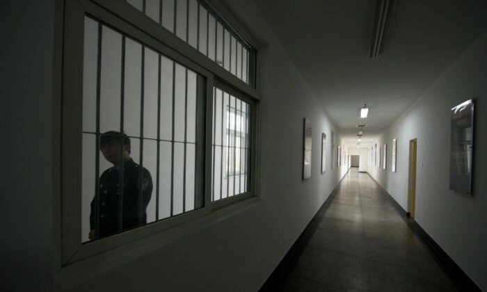 Um guarda olha pela janela de um corredor dentro do Centro de Detenção Nº 1 durante uma visita guiada pelo governo em Pequim, China, em 25 de outubro de 2012. (Ed Jones/AFP via Getty Images)