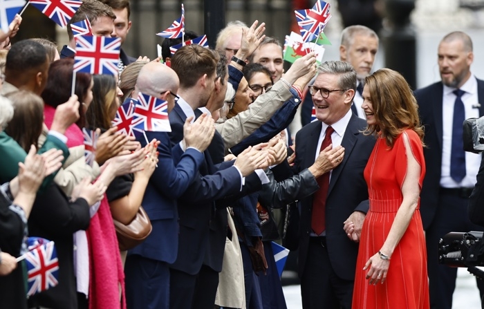 O novo primeiro-ministro da Grã-Bretanha, Keir Starmer (2-dir.), e sua esposa Victoria Starmer acenam para apoiadores ao chegarem à Downing Street em Londres, Grã-Bretanha, 05 de julho de 2024 (EFE/EPA/TOLGA AKMEN)