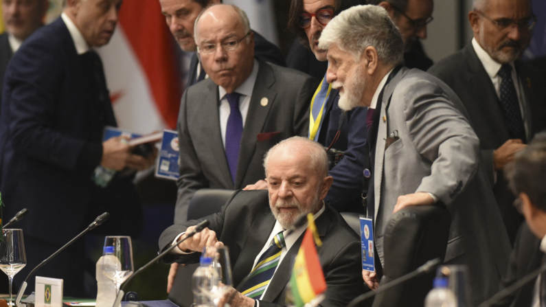 O presidente do Brasil, Luiz Inácio Lula da Silva (centro), seu ministro das Relações Exteriores, Mauro Vieira (à esquerda), e o assessor-chefe da Presidência, Celso Amorim (à direita), participam da cúpula do Mercosul no antigo porto de Assunção em 8 de julho de 2024. A união aduaneira do Mercosul, formada por Brasil, Argentina, Paraguai e Uruguai, se reúne em uma cúpula presidencial marcada pela ausência do argentino Javier Milei e pela entrada da Bolívia como membro pleno. (Foto de DANIEL DUARTE / AFP) (Foto de DANIEL DUARTE/AFP via Getty Images)