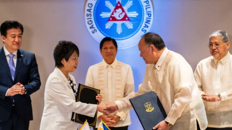 A ministra das Relações Exteriores do Japão, Yoko Kamikawa, e o ministro da Defesa das Filipinas, Gilberto Teodoro, apertam as mãos após assinarem o acordo de acesso recíproco, no Palácio Malacanang em Manila, Filipinas, 8 de julho de 2024. (Lisa Marie David/Reuters)
