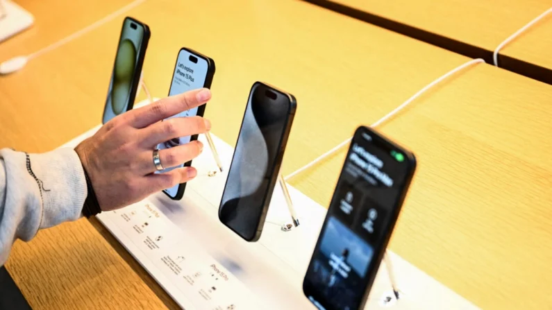 Um cliente compara dispositivos Apple iPhone série 15 exibidos à venda na loja The Grove Apple no dia do lançamento em Los Angeles, Califórnia, em 22 de setembro de 2023. (Patrick T. Fallon/AFP via Getty Images)
