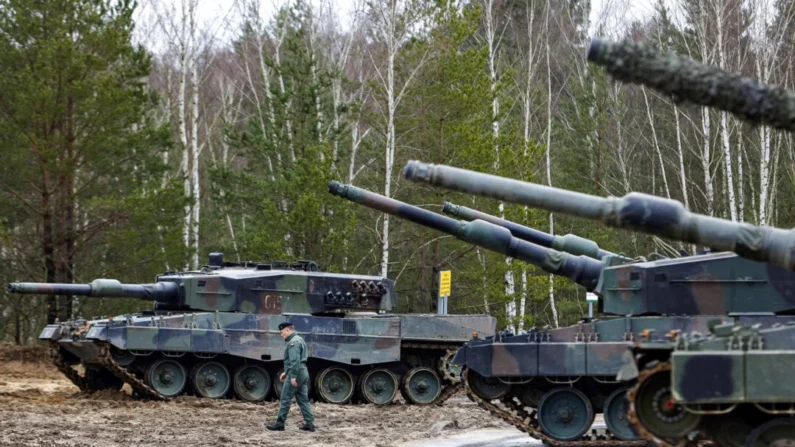 Um soldado polonês caminha ao lado de tanques Leopard 2 durante treinamento em uma base militar e campo de teste em Swietoszow, Polônia, em 13 de fevereiro de 2023. (Michal Dyjuk / AP Photo)
