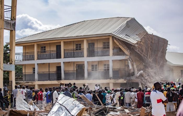 Pessoas se reúnem no local de um prédio que desabou na Saint Academy School em Jos North, distrito do estado de Plateau, Nigéria, em 12 de julho de 2024 (EFE/EPA/RENNISTORIOS BECKY)