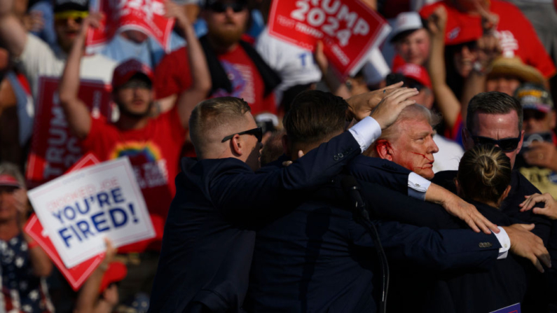 Agentes do Serviço Secreto cercam o candidato presidencial republicano, o ex-presidente Donald Trump, no palco depois que ele foi ferido em um comício em 13 de julho de 2024 em Butler, Pensilvânia (Foto: Jeff Swensen/Getty Images)