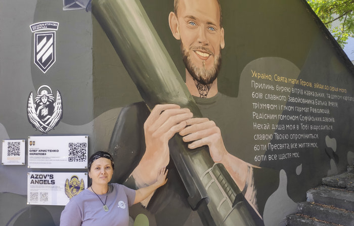 Olena Krylova, mãe do soldado voluntário Oleg Khrystenko, de 21 anos, posa ao lado de um mural dedicado ao seu filho. Murais com retratos de defensores ucranianos mortos aparecem nas ruas de Lviv (oeste), enquanto suas famílias e amigos tentam manter viva sua memória e lembrar aos habitantes da cidade o alto preço pago para repelir os contínuos ataques da Rússia (EFE / Rostyslav Averchuc.)