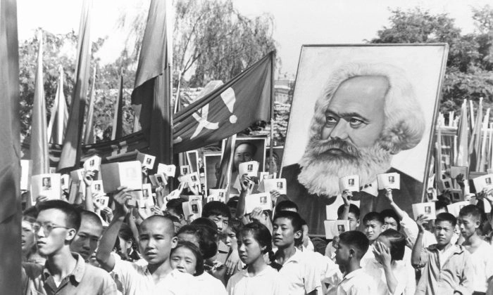 Em uma foto de arquivo, jovens são vistos em um comício durante o auge do levante da Guarda Vermelha, acenando com cópias dos escritos do presidente do Partido Comunista, Mao Tsé-Tung, muitas vezes chamado de Pequeno Livro Vermelho de Mao, e carregando um pôster de Karl Marx. (Foto AP, Arquivo)

