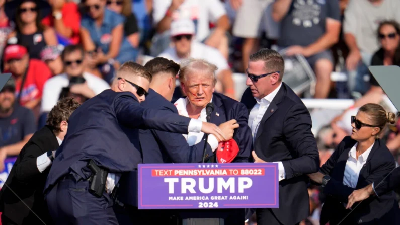 O ex-presidente Donald Trump é ajudado a sair do palco em um evento de campanha em Butler, Pensilvânia, em 13 de julho de 2024. (Gene J. Puskar/AP Photo)
