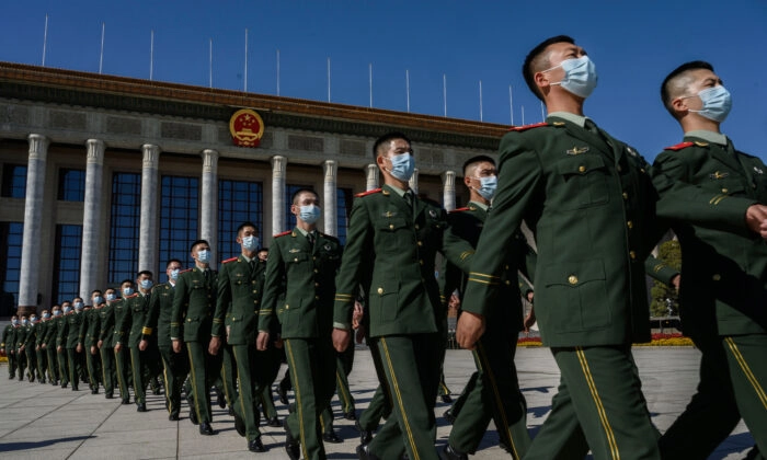 Soldados chineses do Exército de Libertação Popular usam máscaras de proteção enquanto marcham após uma cerimônia que marca o 70º aniversário da entrada da China na Guerra da Coréia, no Grande Salão do Povo em Pequim, China, em 23 de outubro de 2020. (Kevin Frayer /Getty Imagens)
