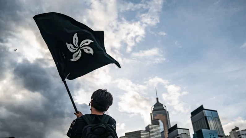 
Um homem agita uma bandeira preta de Hong Kong em uma rua em frente ao Complexo do Conselho Legislativo em Hong Kong, em 1º de julho de 2019. (Anthony Kwan/Getty Images)
