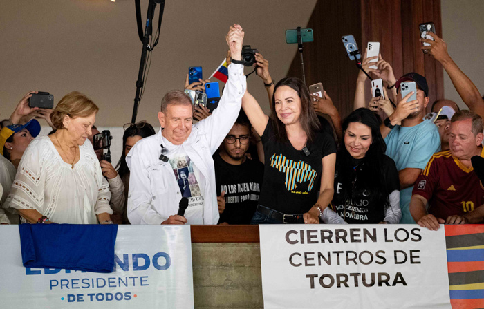 Foto de arquivo mostrando o candidato presidencial venezuelano Edmundo González (c) acenando ao lado da líder da oposição María Corina Machado (2-r) durante um comício de campanha em Caracas (EFE/ Ronald Peña R.)