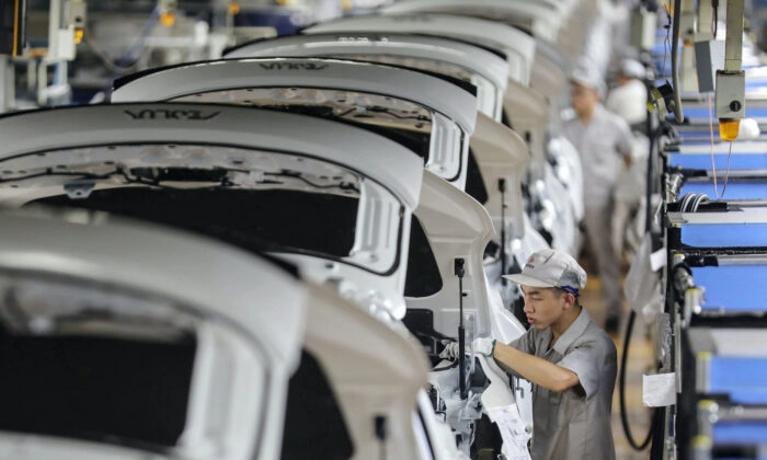 Funcionário trabalhando em uma linha de montagem de automóveis em Wuhan, na província central de Hubei, na China, em 14 de setembro de 2020. (STR/AFP via Getty Images)
