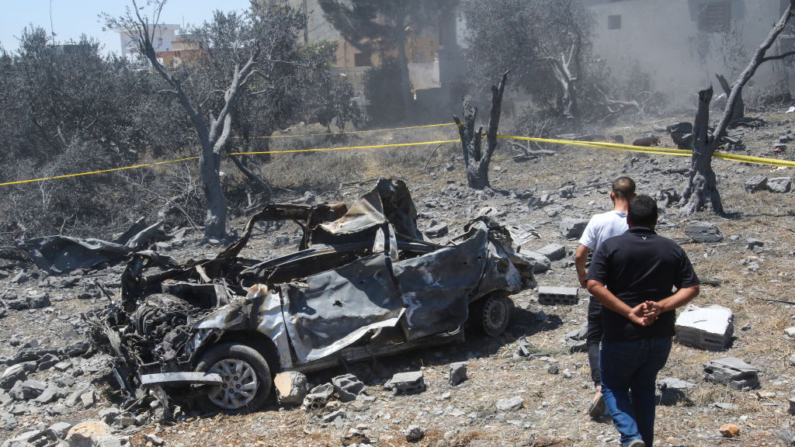 Um veículo destruído em meio a destroços após um ataque aéreo israelense perto da aldeia de Jmaijmeh, no sul do Líbano, em 19 de julho de 2024, enquanto continuam os confrontos transfronteiriços entre as tropas israelenses e os combatentes do Hezbollah do Líbano. Os ataques israelenses em 18 de julho mataram pelo menos cinco pessoas, incluindo o comandante de um grupo terrorista aliado do Hamas no Líbano, segundo grupos militantes e uma fonte de segurança (Foto de MAHMOUD ZAYYAT/AFP via Getty Images)