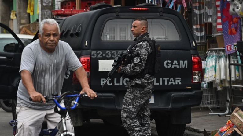 Um policial militar patrulha uma rua na favela Cidade de Deus, zona oeste do Rio de Janeiro, Brasil, em 15 de julho de 2024 (Foto de MAURO PIMENTEL/AFP via Getty Images)