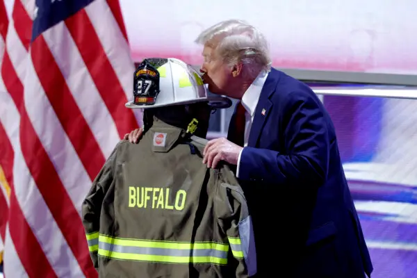 O ex-presidente dos EUA Donald Trump beija um capacete e uma jaqueta de bombeiro que pertenceram a Corey Comperatore no último dia da Convenção Nacional Republicana de 2024 no Fiserv Forum em Milwaukee, em 18 de julho de 2024. (Kamil Krzaczynski/AFP via Getty Images)