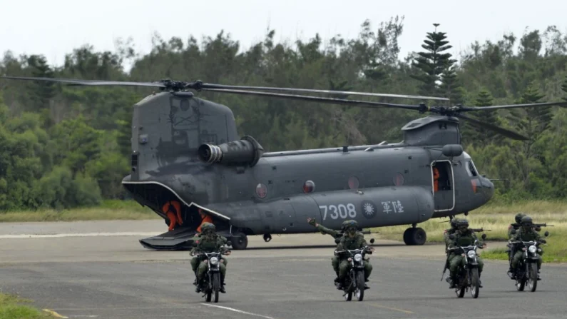 Soldados taiwaneses armados andam de motocicleta ao lado de um helicóptero CH-47 fabricado nos EUA durante o exercício de combate a incêndios "Han Kuang" (Han Glory), a cerca de 6,4 quilômetros da cidade de Magong, nas ilhas remotas de Penghu, em Taiwan, em 25 de maio. 2017. (Sam Yeh/AFP via Getty Images)