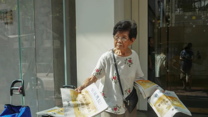 A praticante do Falun Gong, Kitty Jiang, de 95 anos, está distribuindo o Minghui Weekly em 9 de julho de 2024, em Hong Kong. (Adrian Yu/Epoch Times)
