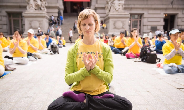 Uma mulher que pratica o Falun Gong medita com outras pessoas perto do Battery Park, em Manhattan, durante o Dia Mundial do Falun Dafa, em 13 de maio de 2015. (Laura Cooksey)
