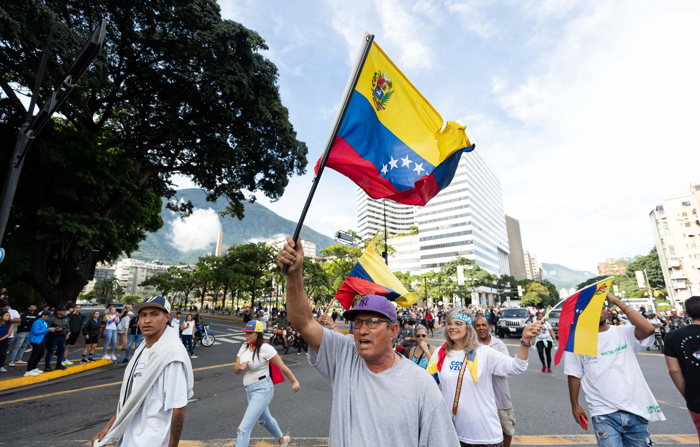 Pessoas participam de um protesto contra os resultados da eleição presidencial na segunda-feira em Caracas, Venezuela. Centenas de pessoas se manifestam em Caracas depois que o Conselho Nacional Eleitoral (CNE) proclamou Nicolás Maduro como presidente reeleito da Venezuela, após as eleições realizadas em 28 de julho (EFE/ Ronald Peña)