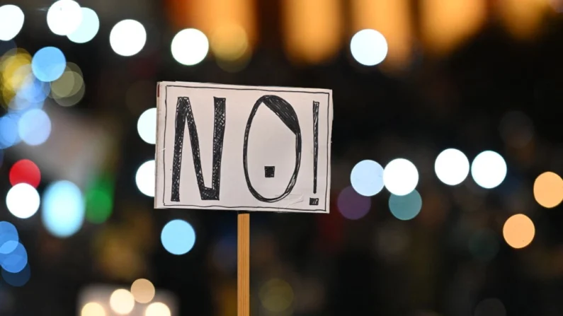 Um cartaz com a inscrição "NÃO! (com bigodes)" é retratado durante uma manifestação contra o racismo, o antissemitismo e o discurso de ódio, chamada "Mar de luzes para a democracia" (Lichtermeer für Demokratie) no parque de exposições Theresienwiese em Munique, no sul da Alemanha, em 11 de fevereiro de 2024. (Lukas Barth/AFP via Getty Images)
