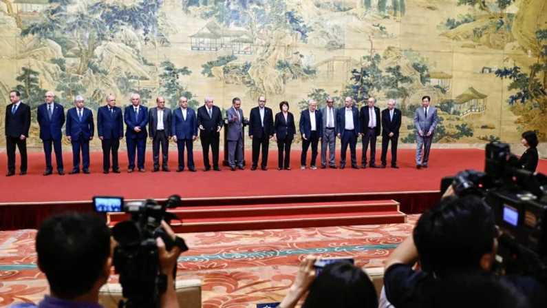 O ministro das Relações Exteriores da China, Wang Yi (C), posa para uma foto de grupo com membros das facções palestinas durante a assinatura da "declaração de Pequim" na Diaoyutai State Guesthouse em Pequim, em 23 de julho de 2024. (PEDRO PARDO/POOL/AFP via Getty Imagens)
