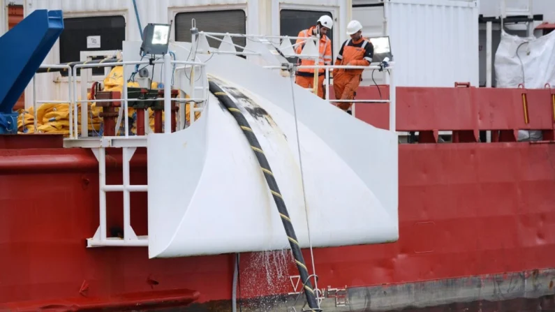 Funcionários instalam um cabo submarino elétrico e uma fibra óptica entre Quiberon e Belle-Ile-en-mer, no oeste da França, em 11 de março de 2015. (Jean-Sebastien Evrard/AFP via Getty Images)