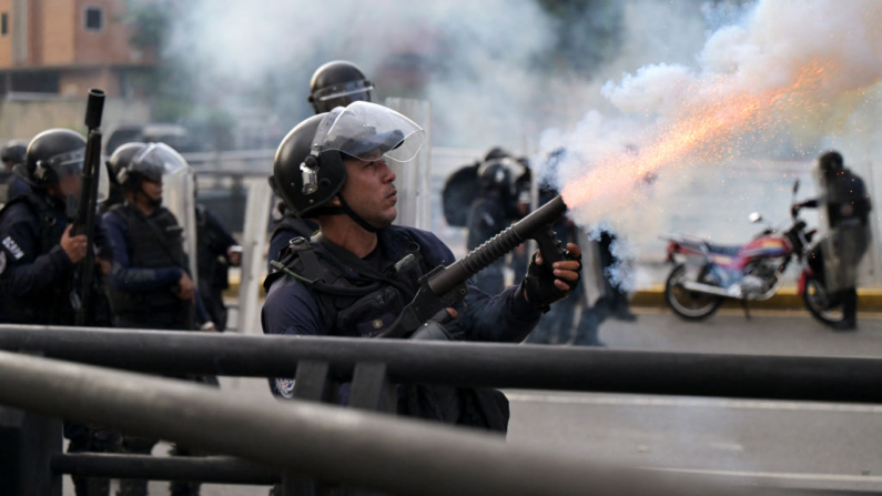 Um policial dispara gás lacrimogêneo durante um protesto contra Nicolas Maduro em Caracas, em 29 de julho de 2024, um dia após a eleição presidencial venezuelana (Foto de YURI CORTEZ/AFP via Getty Images)