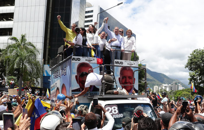 A líder da oposição venezuelana María Corina Machado (à esquerda, acima) e o candidato à presidência da Venezuela Edmundo González Urrutia (à direita, acima) participam de um comício de apoio na terça-feira em Caracas (EFE/Ronald Peña R.)