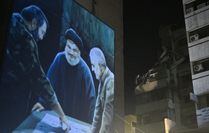 Um pôster do líder do Hezbollah, Hassan Nasrallah (centro), de um membro sênior do grupo, Imad Mughniyeh (esq.), e do major-general iraniano Qassem Soleimani (dir.), é visto perto do local que foi alvo de um ataque israelense, no subúrbio sul de Beirute, Líbano, em 30 de julho de 2024 (EFE/EPA/WAEL HAMZEH)