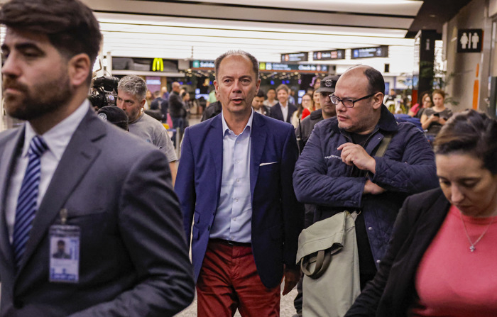 Nicolas Mangiarotti (centro), encarregado de negócios da embaixada argentina na Venezuela, chega ao aeroporto de Ezeiza (Buenos Aires) depois de ser expulso da Venezuela pelo governo de Nicolas Maduro no sábado (EFE/Juan Ignacio Roncoroni)