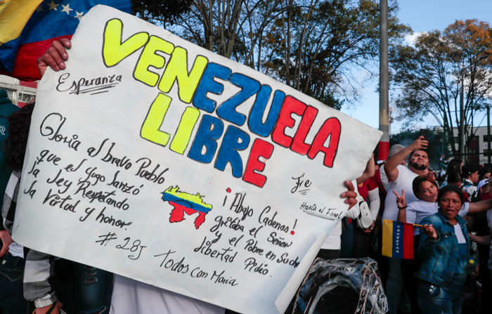 Cidadãos venezuelanos aguardam os resultados das eleições na Venezuela no domingo, em Quito, Equador (EFE/ José Jácome)