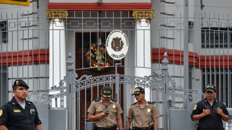 Policiais montam guarda na entrada da embaixada venezuelana em Lima, enquanto um grupo de venezuelanos que vivem no Peru protesta contra o novo mandato do presidente venezuelano Nicolas Maduro, em 10 de janeiro de 2019 (Foto de CRIS BOURONCLE/AFP via Getty Images)