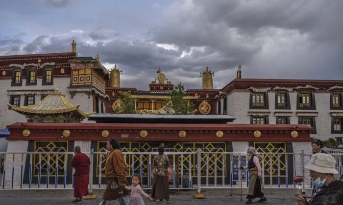 Budistas tibetanos caminham a kora em frente ao Templo Jokhang, um patrimônio da UNESCO, em 1º de junho de 2021 em Lhasa, região do Tibete, China. (Kevin Frayer/Getty Images)
