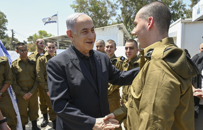 O primeiro-ministro israelense Benjamin Netanyahu (c) visita os recrutas do Corpo Blindado e do Corpo de Engenharia de Combate do exército israelense na base de Tel Hashomer, perto de Tel Aviv. Netanyahu disse na quarta-feira que Israel está preparado "tanto para a defesa quanto para o ataque" diante da ameaça de um ataque multifacetado orquestrado pelo Irã. (EFE/Gabinete do Primeiro Ministro de Israel)