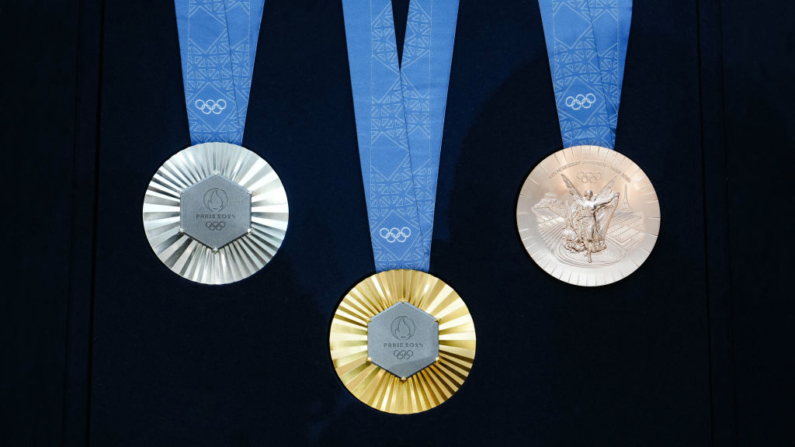 Esta fotografia tirada em Paris em 8 de fevereiro de 2024 mostra as medalhas olímpicas durante a revelação das medalhas olímpicas e paralímpicas dos Jogos Olímpicos de Paris 2024. No lado da cabeça das medalhas, as figuras gravadas da deusa da vitória Atena, Nike, o estádio Panatenaico e a Acrópole são impostas pelo Comitê Olímpico Internacional (COI), mas Paris 2024 obteve autorização excepcional para adicionar o desenho da Torre Eiffel e usar 18 gramas de metal da Torre Eiffel em cada medalha, extraído de pedaços da torre (Foto de DIMITAR DILKOFF/AFP via Getty Images)