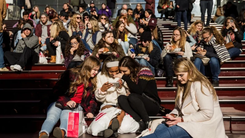 Um grupo de adolescentes olha para uma foto tirada com um smartphone na Times Square, na cidade de Nova Iorque, em 1º de dezembro de 2017. (Drew Angerer/Getty Images)
