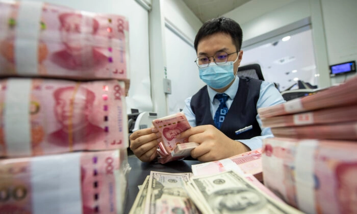 Um homem contando Yuan Chinês (CFOTO/Publicação Futura via Getty Images)
