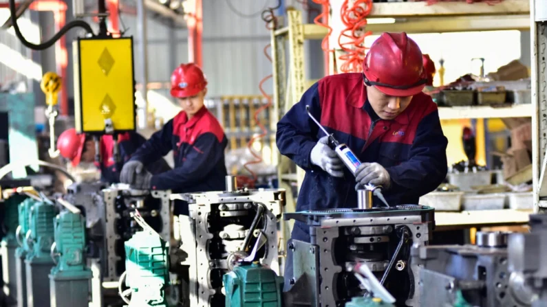 Funcionários trabalham em motores em uma fábrica em Qingzhou, na província de Shandong, no leste da China, em 30 de novembro de 2023 (STR/AFP via Getty Images)
