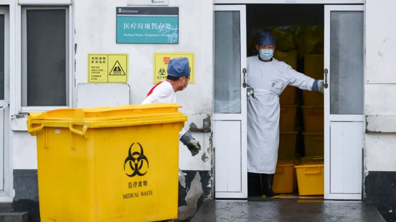 Um trabalhador transporta uma lixeira cheia de lixo médico para um depósito de um hospital em Pequim, China, em 14 de fevereiro de 2020. (Greg Baker/AFP via Getty Images)
