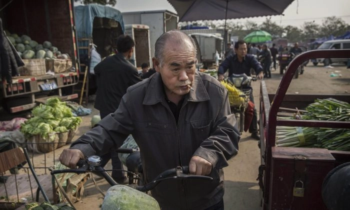 Um aposentado chinês faz compras em um mercado local de alimentos em Pequim, China, em 14 de outubro de 2015 (Kevin Frayer/Getty Images)
