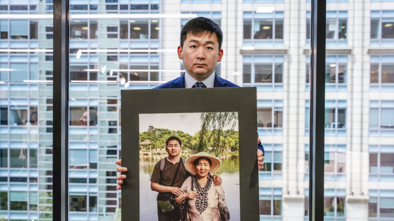 Simon Zhang, um arquiteto da cidade de Nova Iorque, segura uma foto dele e de sua mãe, que foi torturada até a morte na China, em um painel de discussão marcando o 25º ano da perseguição do Partido Comunista Chinês ao Falun Gong, em Washington, em 17 de julho de 2024 (Caroline Li/Epoch Times)