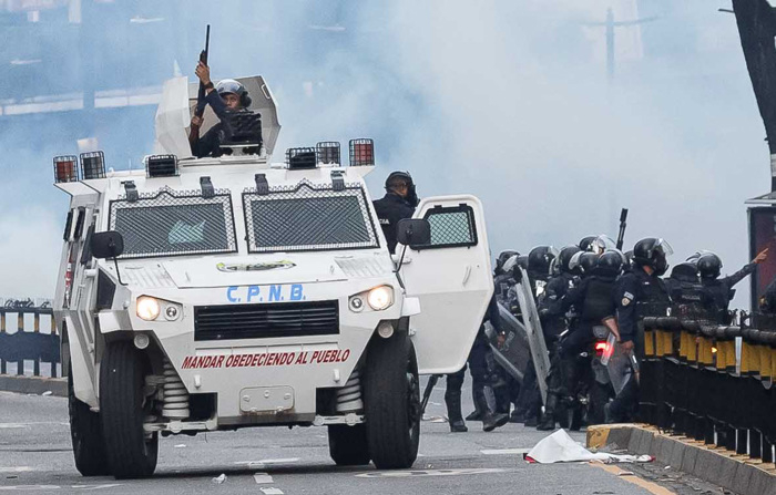 Imagem de arquivo de membros da Polícia Nacional Bolivariana (PNB) confrontando manifestantes durante um protesto contra os resultados das eleições presidenciais, em Caracas (EFE/Ronald Peña R.)