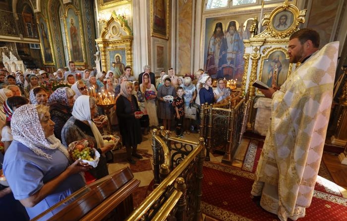 Russos deslocados da fronteira ucraniana em Kursk participam de missa em 19 de agosto (EFE/EPA/STRINGER)